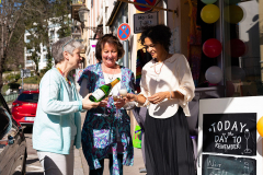 Die Ladenbesitzerinnen stoßen mit einem Gläschen Sekt auf die Wiedereröffnung an